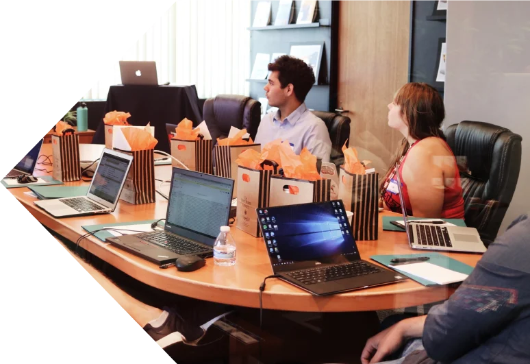 A team working on laptops around a boardroom table