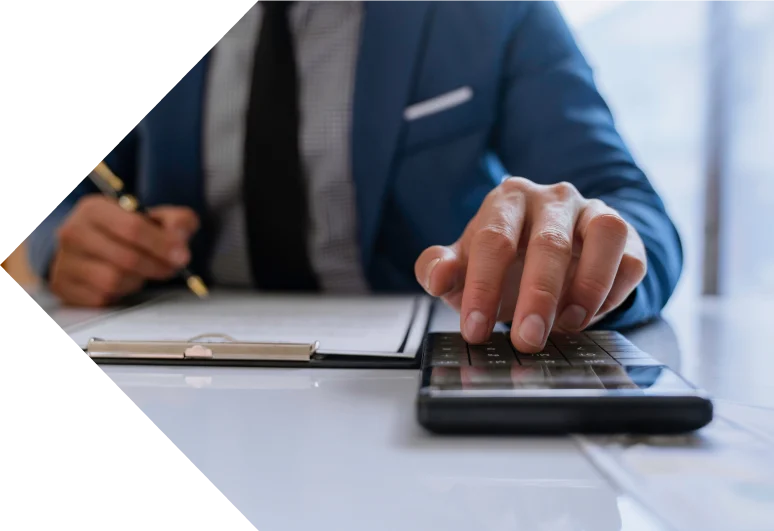 An accountant using a calculator while signing paperwork